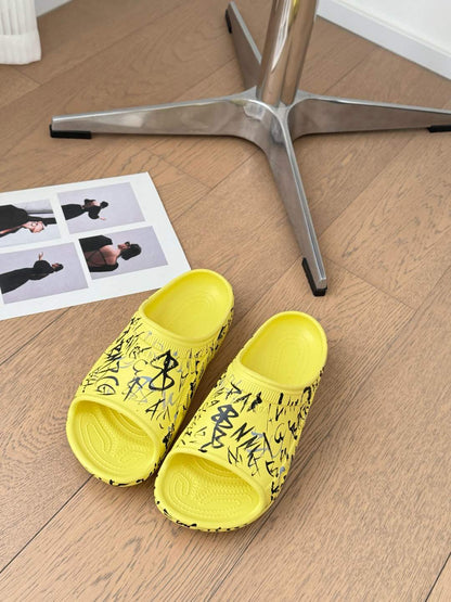 POOL GRAFFITI CROCS SLIDE SANDALS IN YELLOW AND BLACK RUBBER